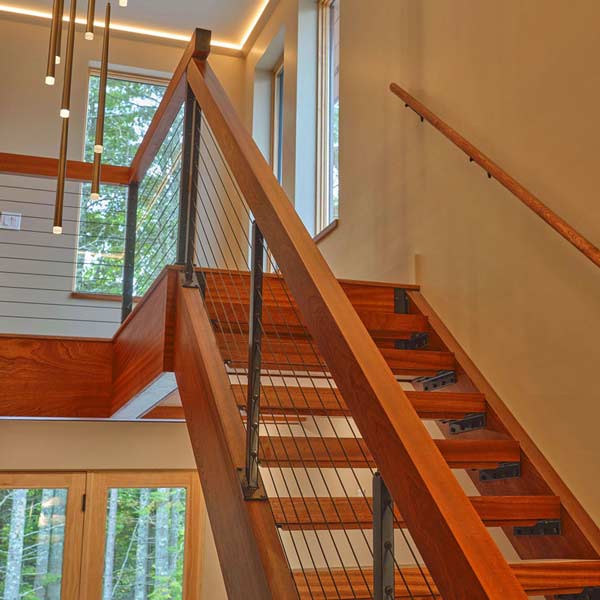 Custom Sapele open stairway with tread, stringers, rails and cable system in Bar Harbor, Maine by Spiritcraft Furniture