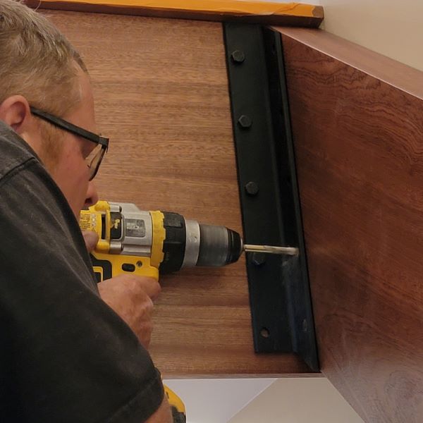 Custom stair tread and stringer bracket installation - note the detail, installed with black oxide lag screws