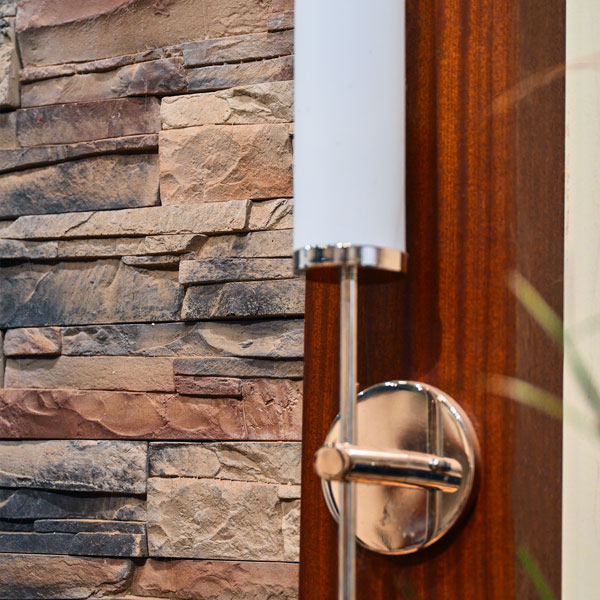 Interior Faux Column Framing Stonework with Sconce Lighting in Stained Ribbonstripe African Mahogany