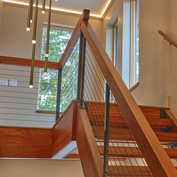 Custom Sapele open stairway with tread, stringers, rails and cable system in Bar Harbor, Maine by Spiritcraft Furniture