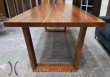 Mid Century Modern influenced solid slab dining table in Ribbonstripe Sapele Mahogany with trapezoid legs by Spiritcraft Design Funriture of East Dundee, IL.